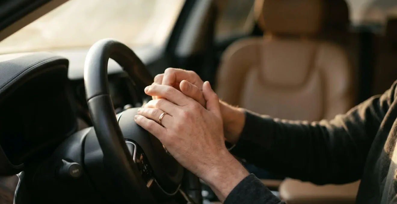 Portrait of a driver's hands on steering wheel showing natural interaction with connected vehicle technology