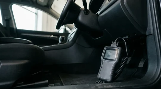 Professional automotive diagnostic scene with OBD2 scanner device connected to vehicle diagnostic port