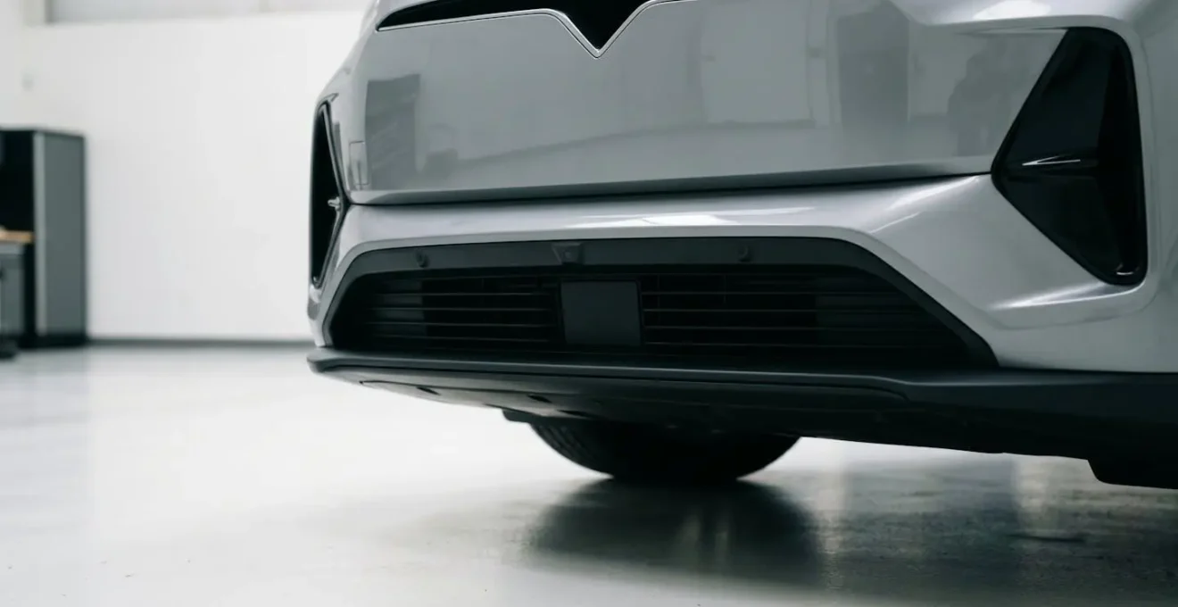 Close-up view of automotive front sensor array showing radar and camera integration zones on vehicle bumper